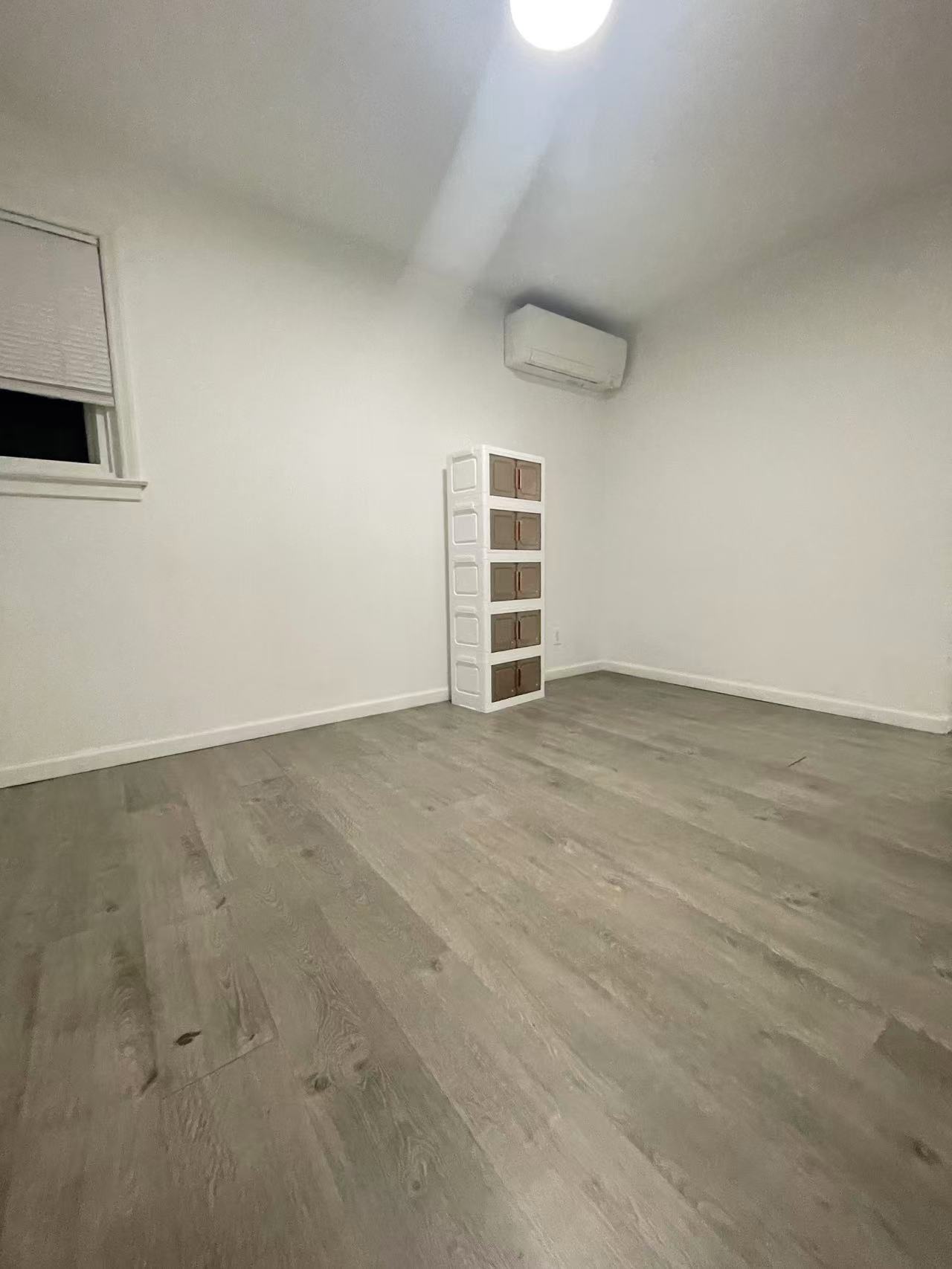 Second bedroom or home office with modern flooring and individual climate control in a Fresh Meadows 11365 home rental.